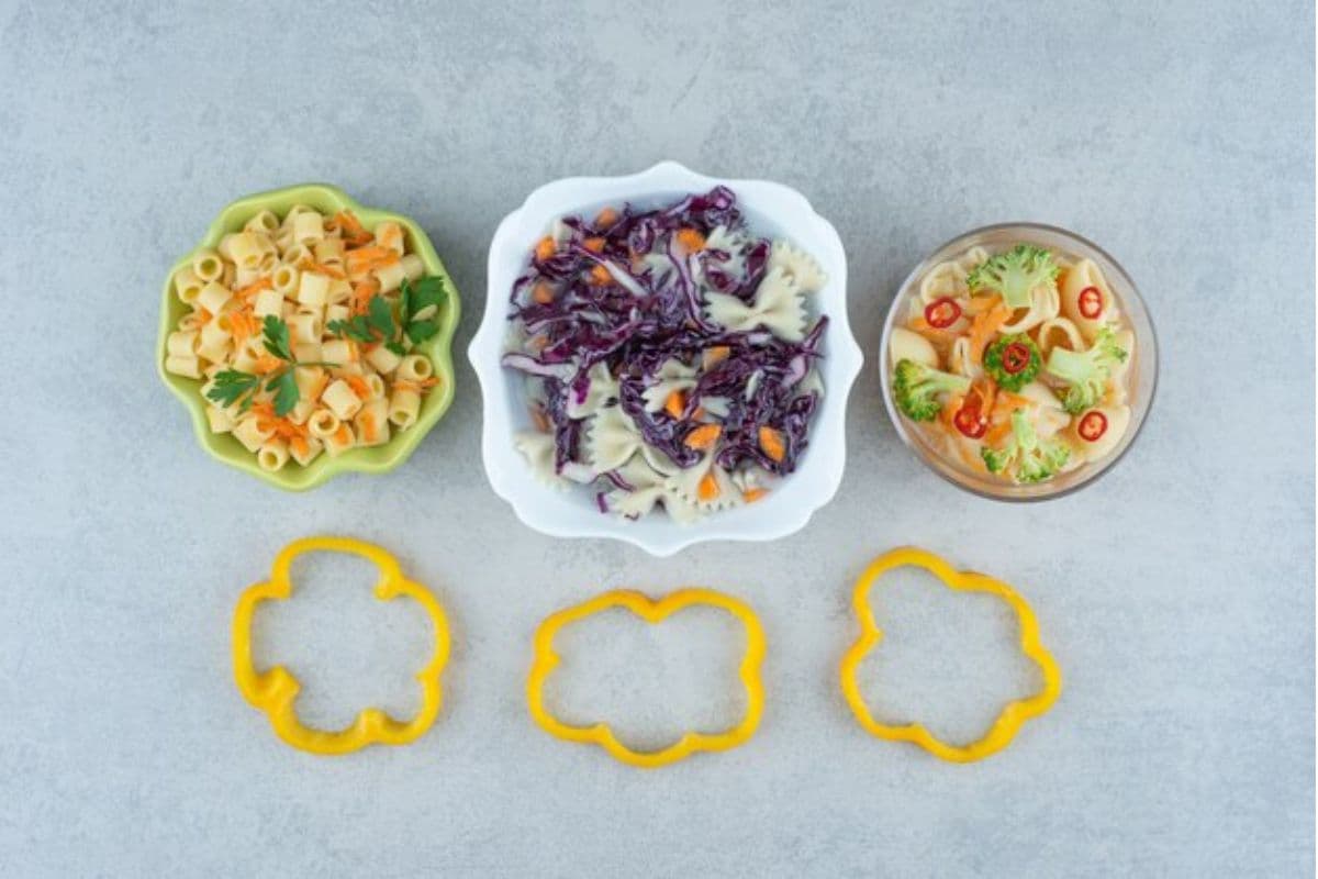 Tiga piring kecil berisi salad dan pasta