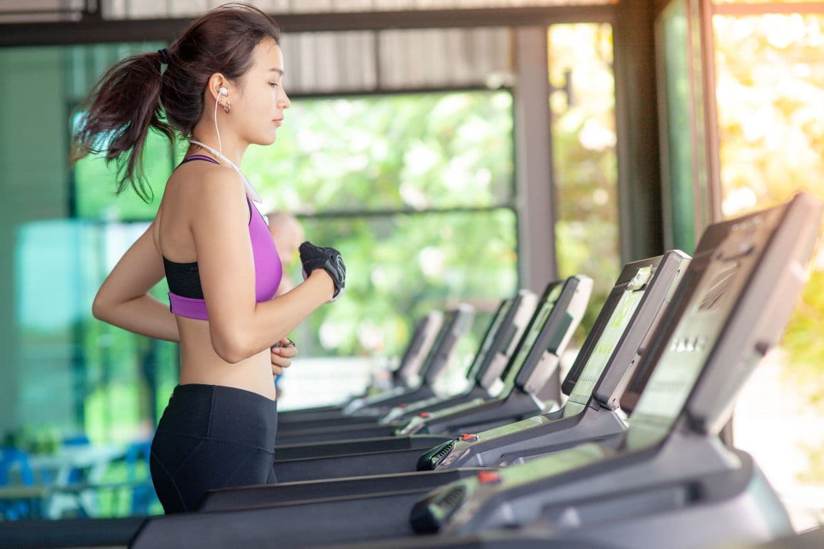 Potret perempuan sedang berlari di treadmill