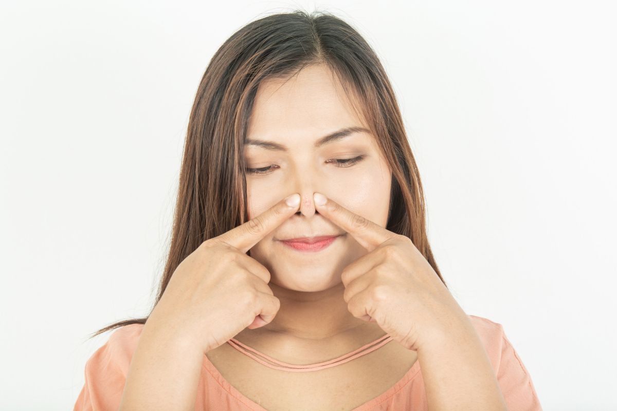 Seoarang wanita sedang memecah jerawat di hidung