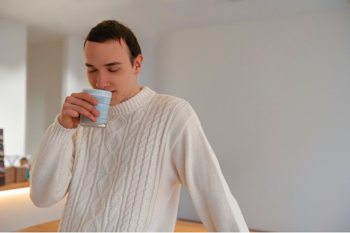 Laki-laki memegang gelas biru