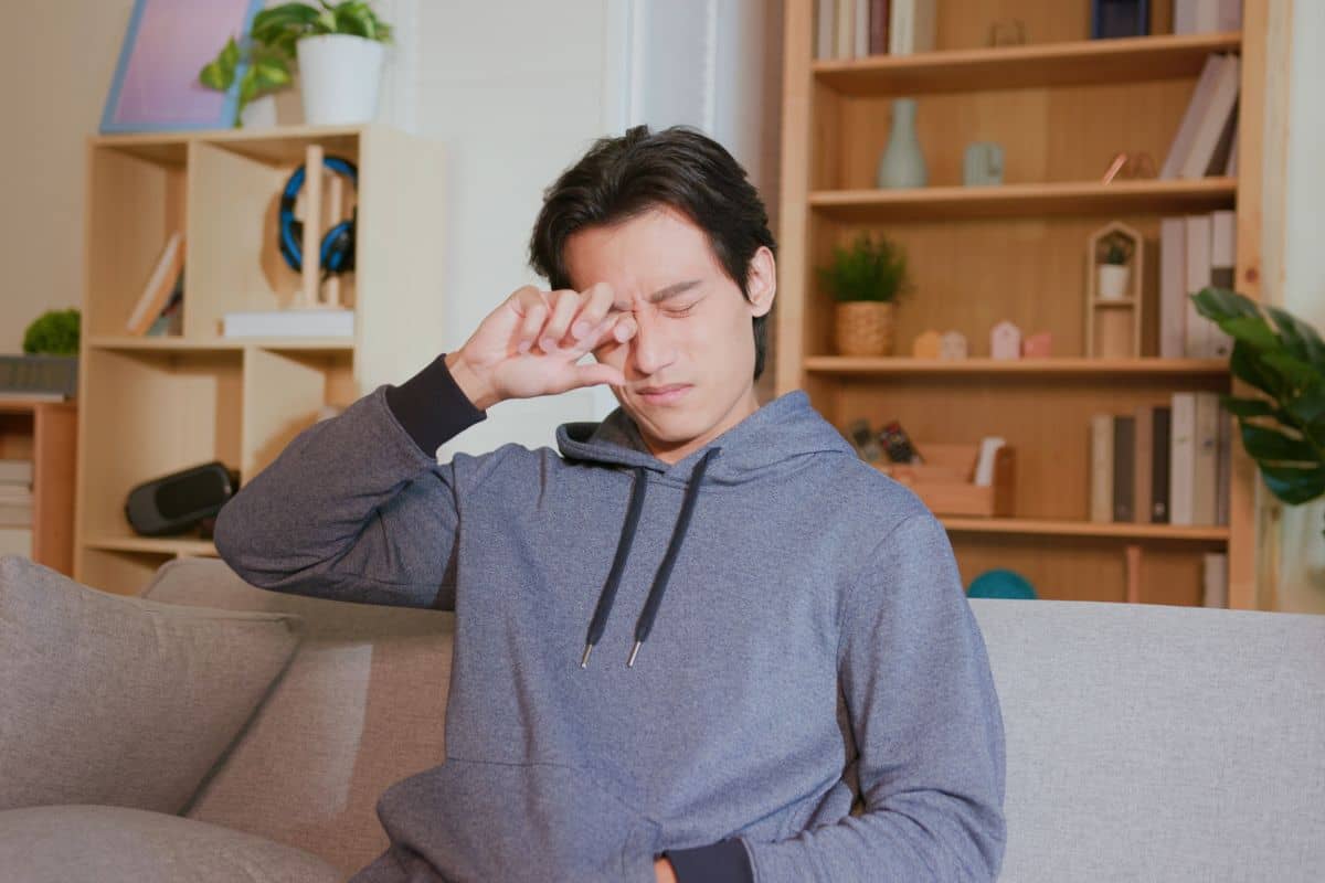 Seorang pria sedang mengucek mata