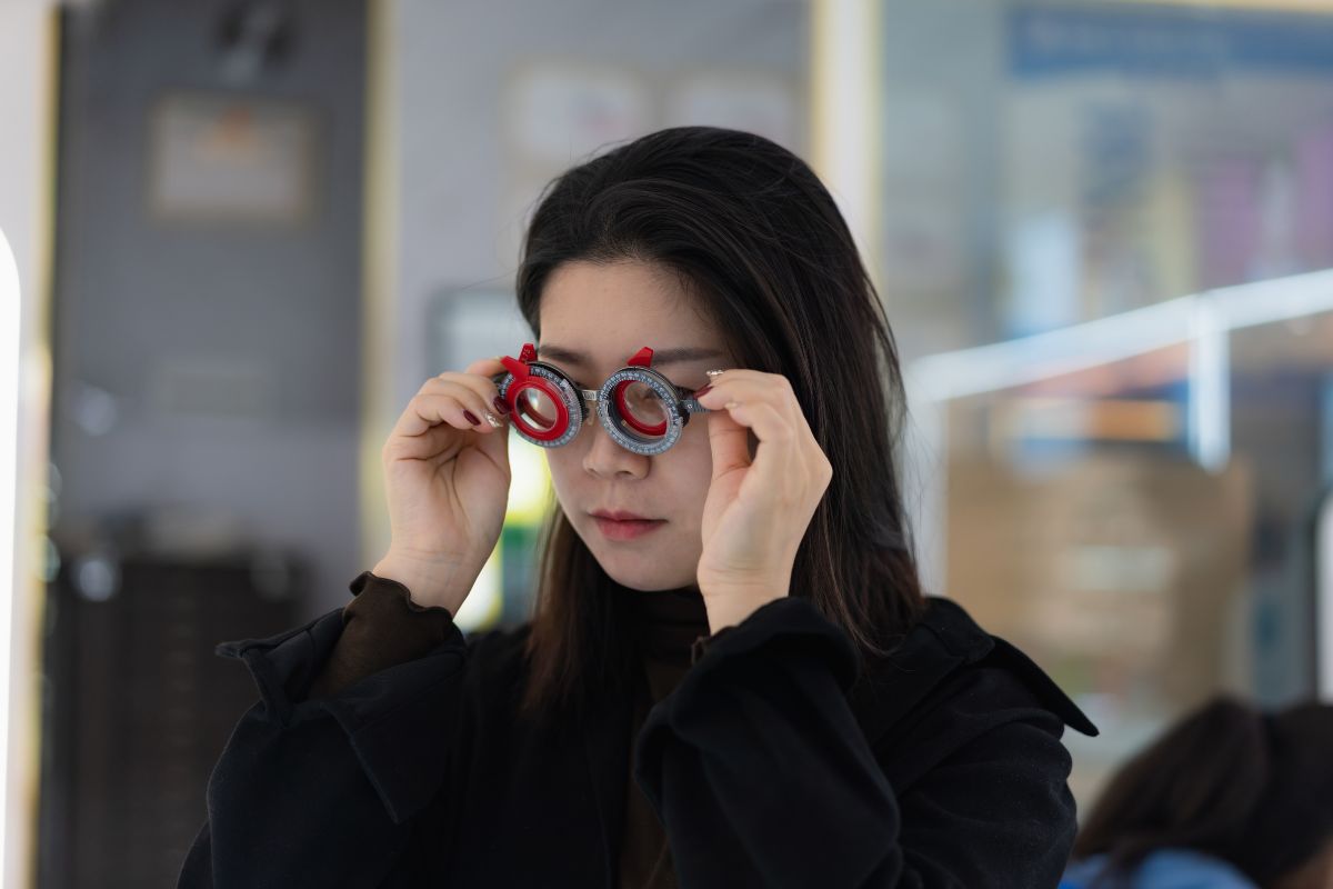 seorang wanita sedang menggunakan kacamata uji untuk mengetahui kemampuan mata