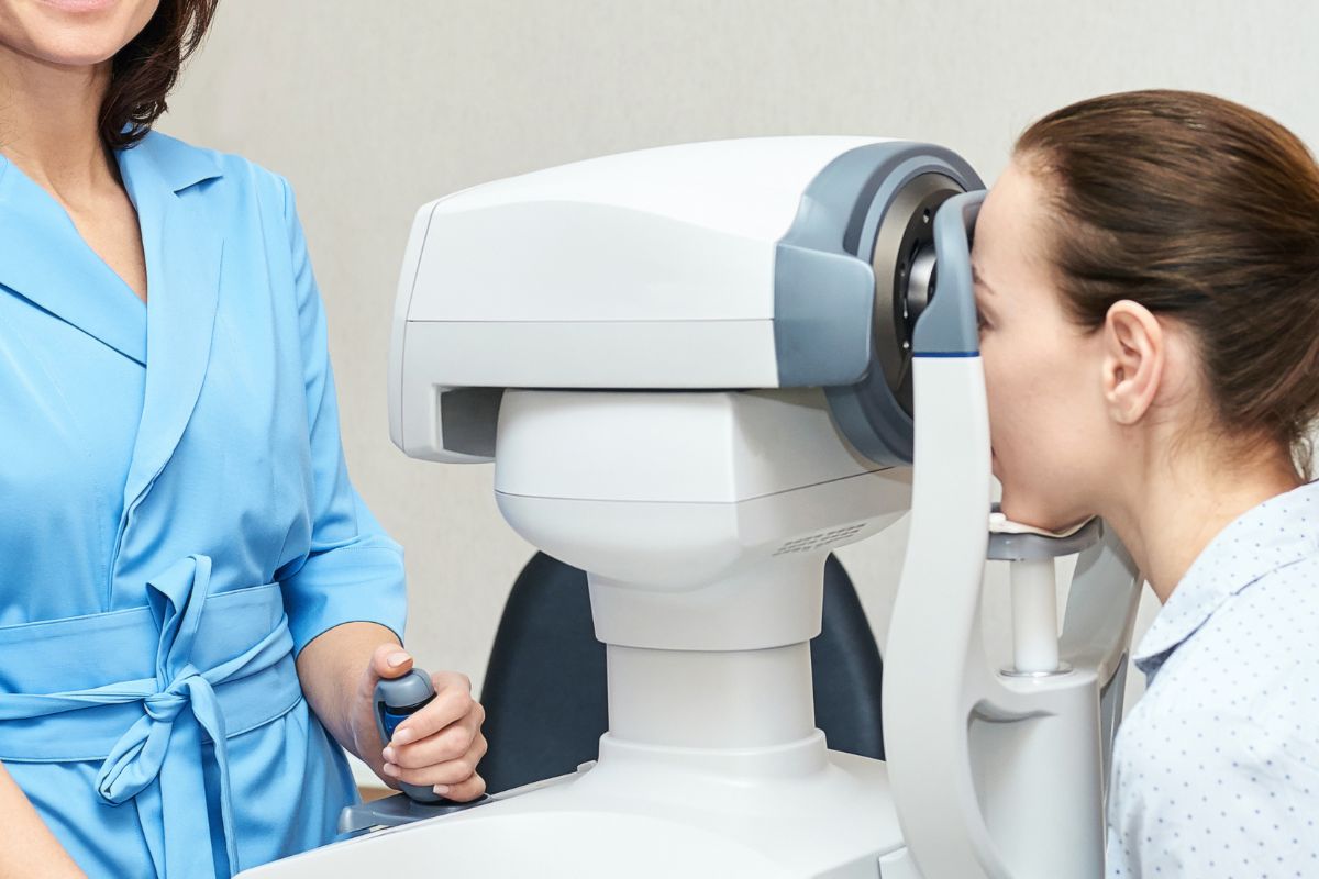 Seorang wanita sedang melakukan pemeriksaan rabun dekat dengan autorefractor
