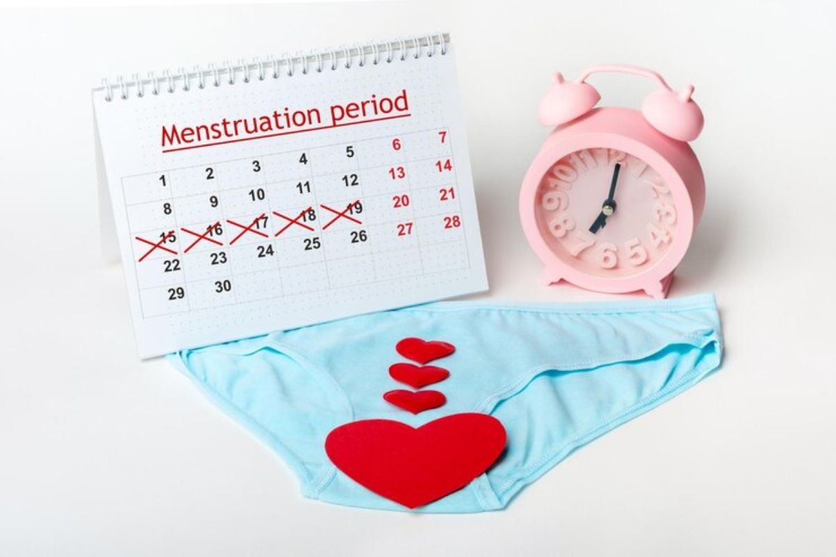 Celana dalam wanita dengan potongan kertas berbentuk hati, kalender, dan jam weker pink