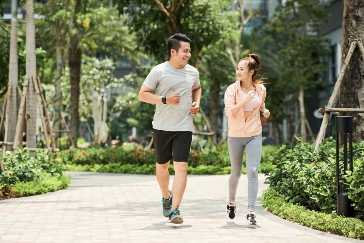 Pria dan wanita sedang jogging di taman