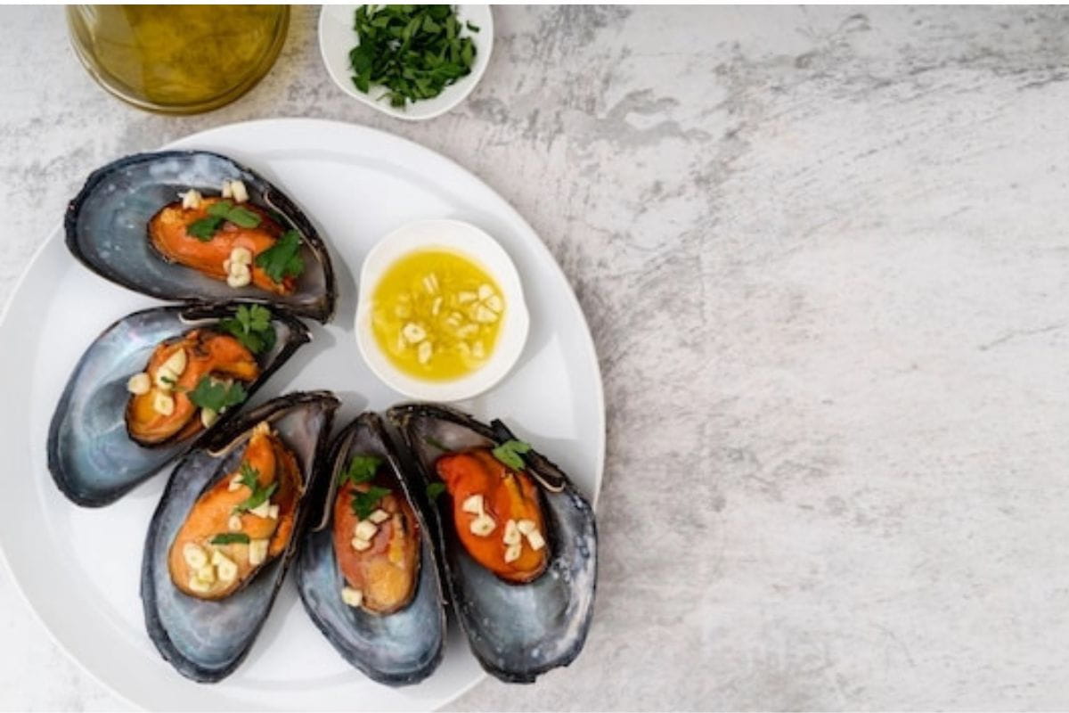 Masakan kerang hijau di atas piring putih