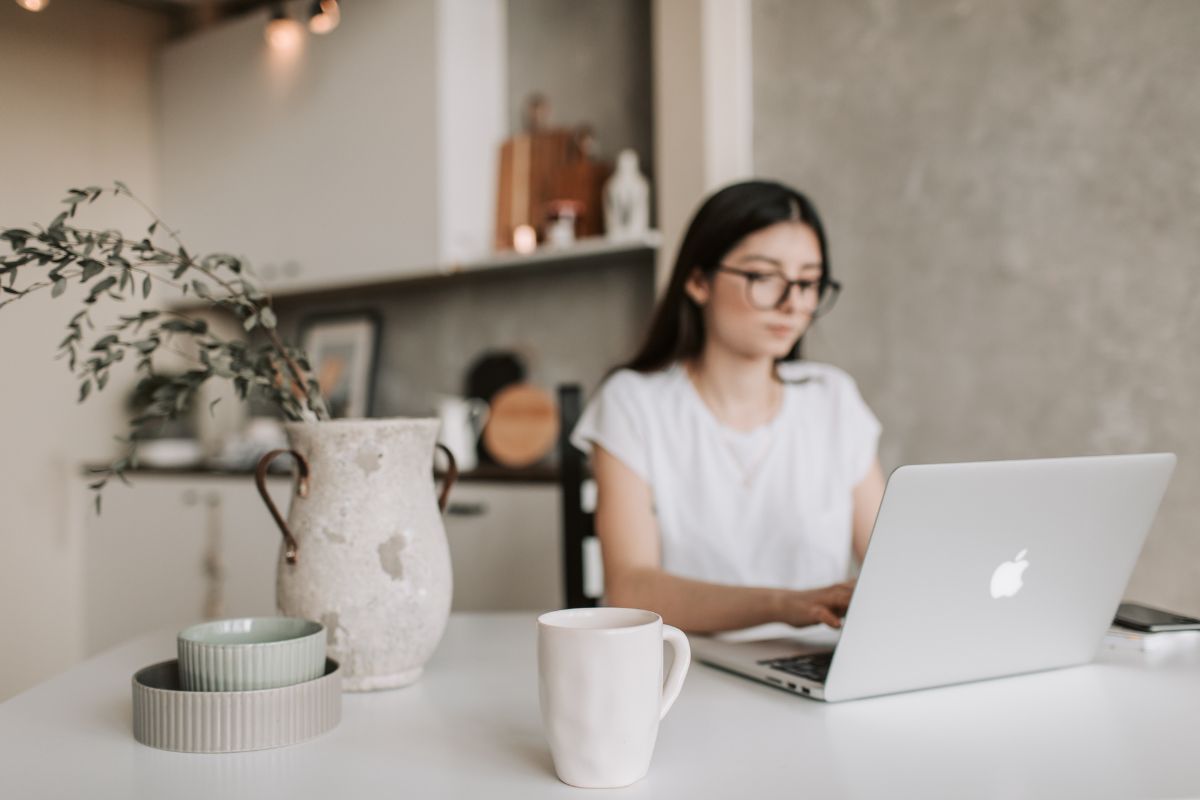 Seorang wanita sedang fokus bekerja di depan laptop