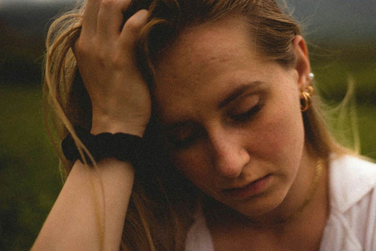 wanita yang memegang kepala karena stress