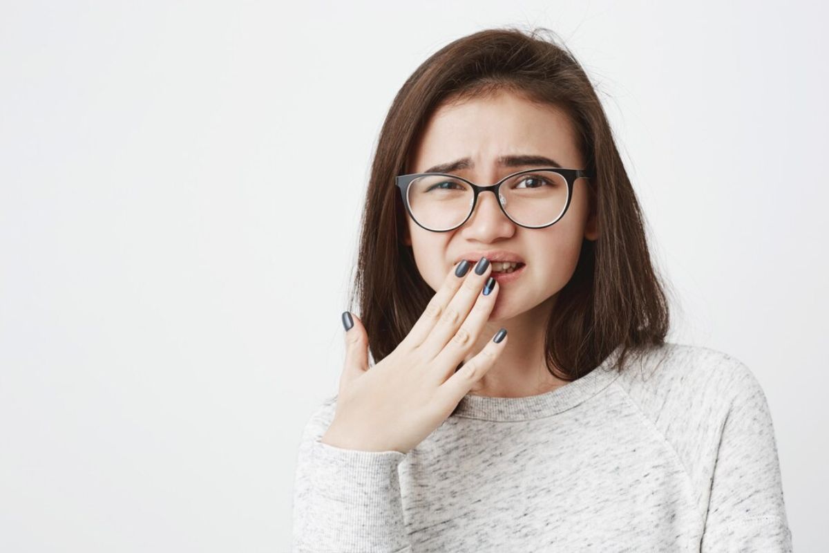 Perempuan berkacamata menutupi mulutnya