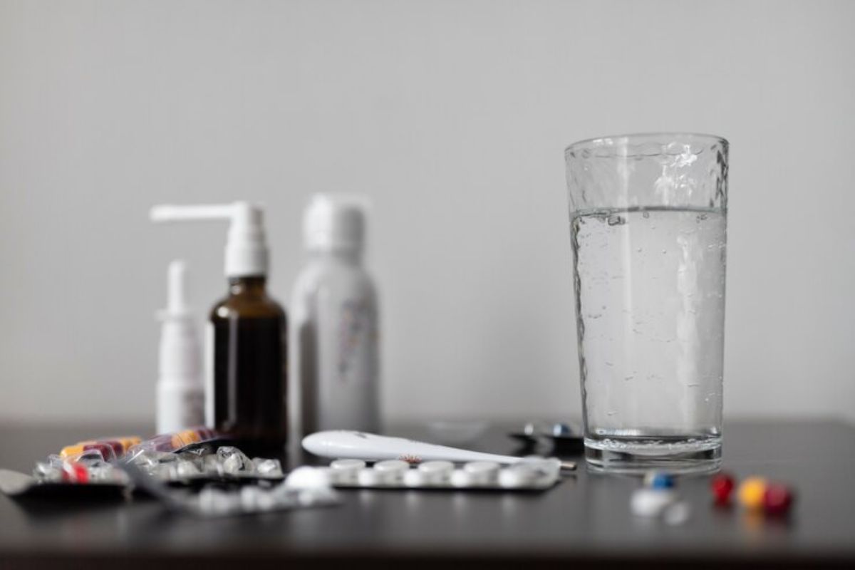 Obat-obatan dan segelas air di atas meja