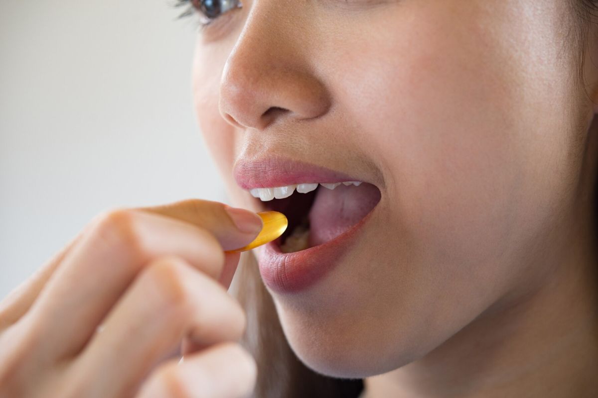 Seorang wanita sedang meminum suplemen