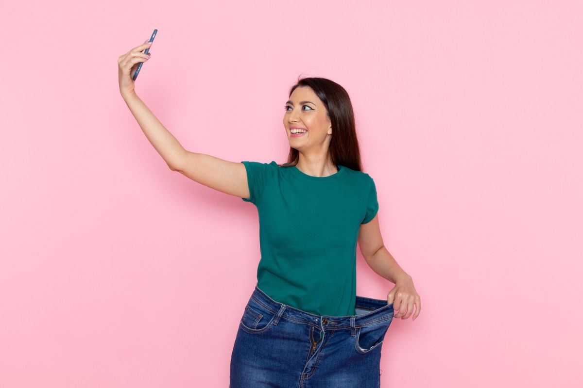 Seorang wanita mengambil foto menunjukan berat badan yang menurun