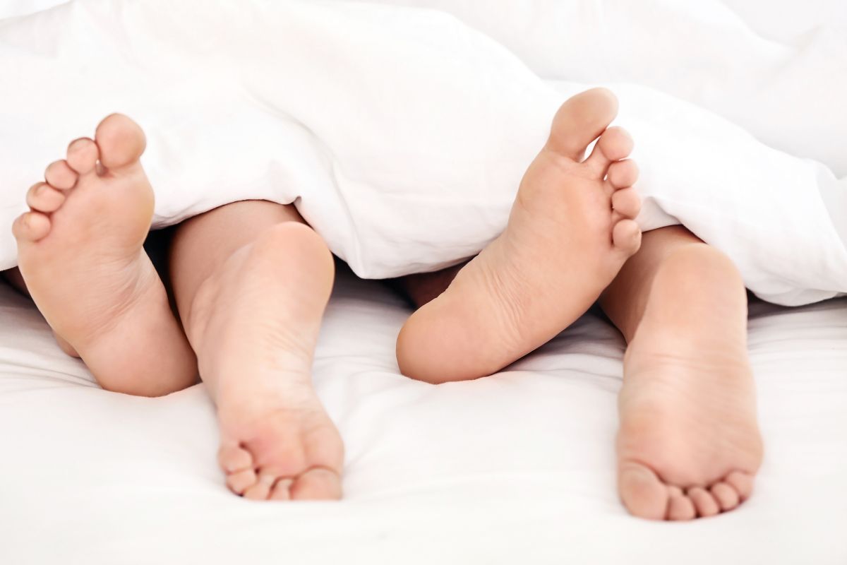 Pasangan yang sedang berpelukan dibawah selimut