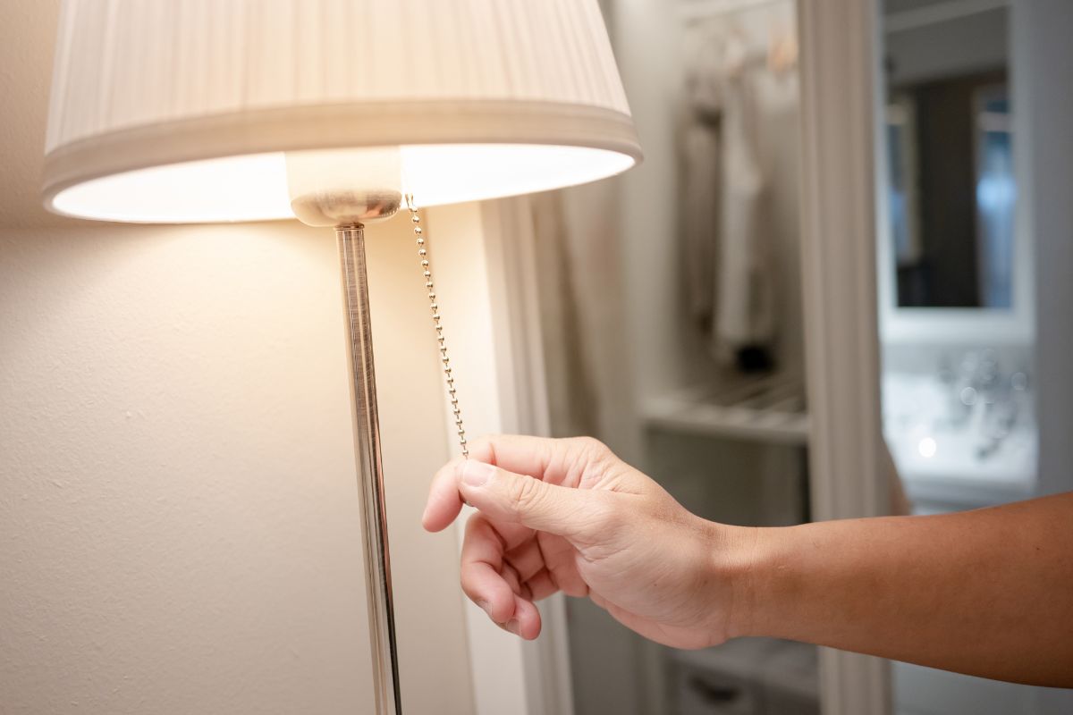 Tangan menyalakan lampu tidur