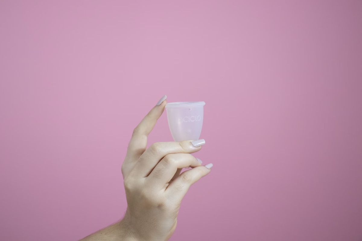 Perempuan memegang menstrual cup