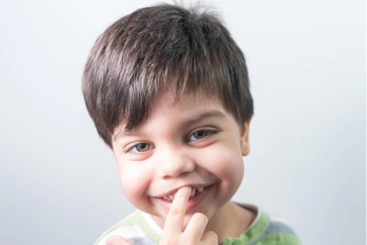 Anak laki-laki menunjuk giginya