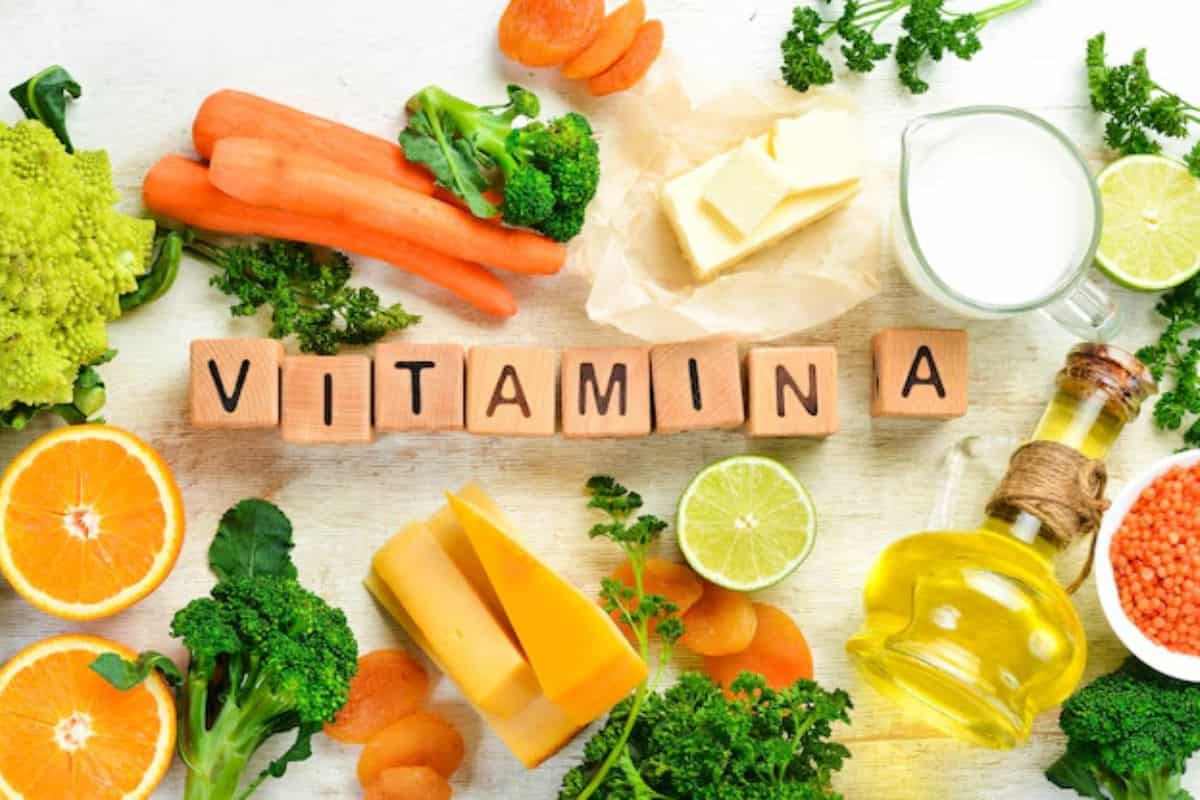 Berbagai makanan sumber vitamin A dan susunan balok kayu bertuliskan 